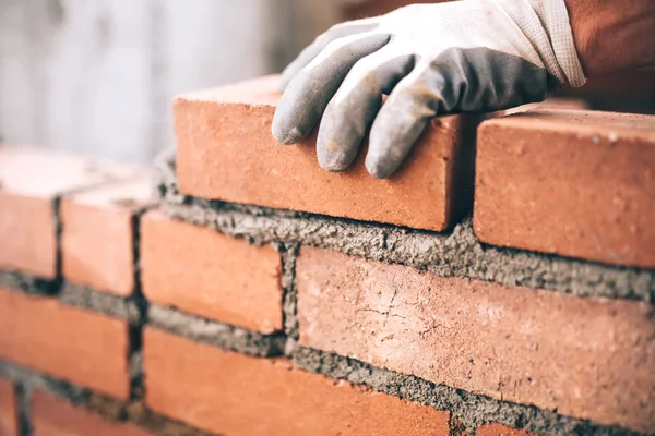 Close up of industrial bricklayer installing bricks on construction site — Stock Photo, Image