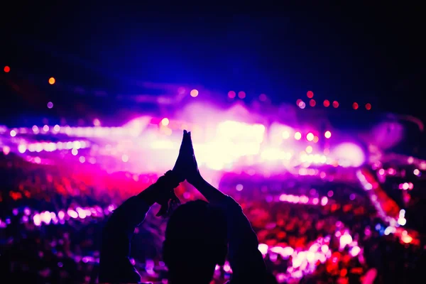 Silueta de mujer aplaudiendo y disfrutando de un concierto en el festival de música . —  Fotos de Stock