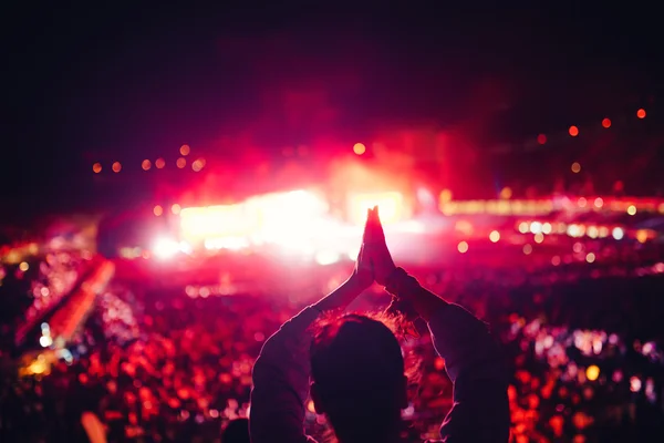 Silhouette of a young woman enjoying festival lights and concert. Woman making hand gestures at concert — Stock Photo, Image