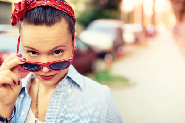 Bela menina hipster vestindo óculos de sol e acessórios de moda. Sorrindo menina fazendo caras engraçadas no estilo de vida retrato — Fotografia de Stock