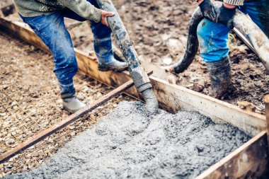 sanayi işçileri büyük işleme pompa tüp ve yeni inşaat sahasında güçlendirilmiş çubuklarında yağan taze beton çimento