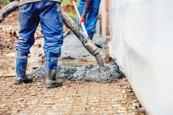Konstruktionsdetails - Arbeiter verlegen Zement oder Beton mit automatischer Pumpe — Stockfoto