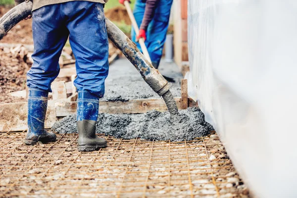 Constuction details - worker laying cement or concrete with automatic pump — Stock Photo, Image