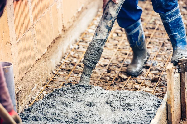 Nahaufnahme von Industriearbeitern, die Zement oder Beton mit automatischen Pumpenschläuchen gießen — Stockfoto