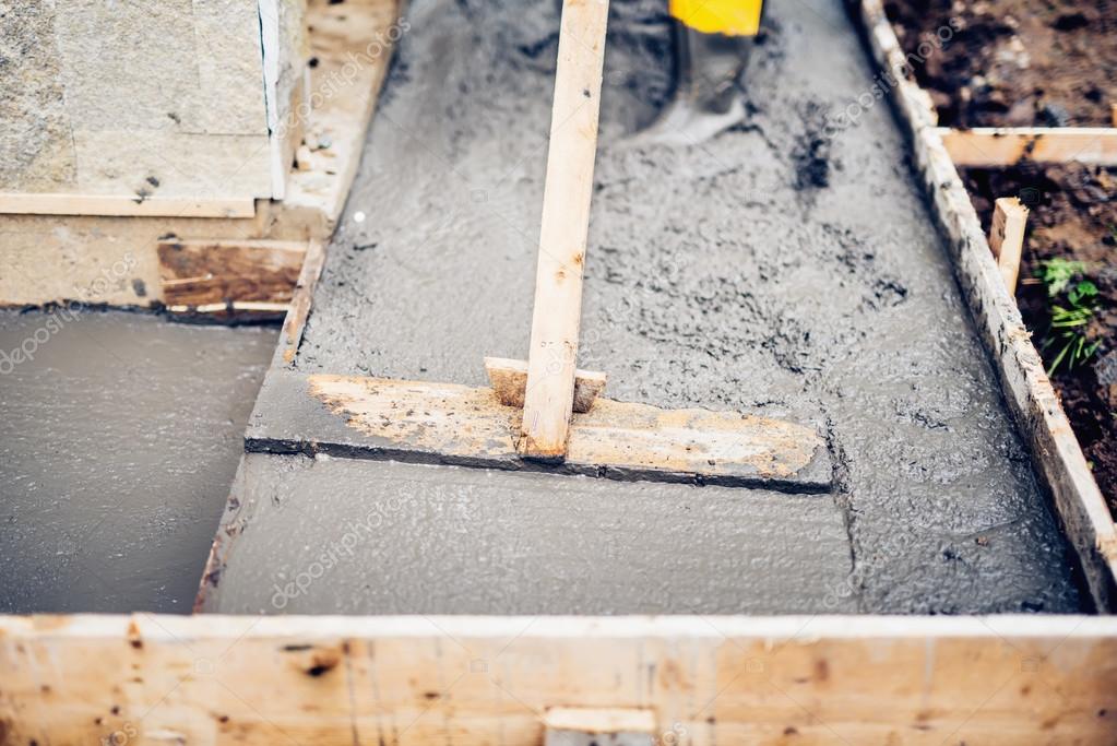 Mason Building And Leveling A First Layer Of Fresh Concrete Floor