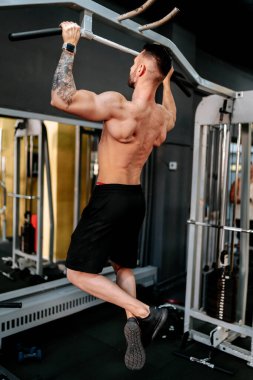 Vücut geliştirici spor salonunda barfiks çekiyor. Sağlıklı yaşam tarzı