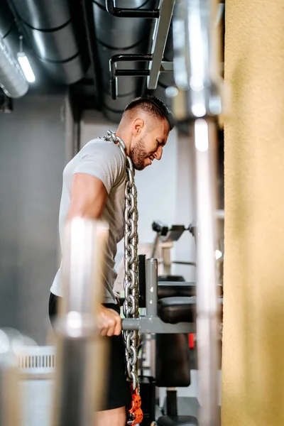 ボディビルダーハンサムな強い運動男は首の周りの鉄の鎖でトリップやバイキップ筋肉を動作します ワークアウトフィットネスとボディビルディングの健康的なコンセプト — ストック写真