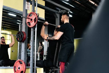 Spor salonunda kişisel antrenör müşteriye yardım ve asistanlık ediyor. Kişisel eğitimli sağlıklı yaşam tarzı uygunluk oturumu