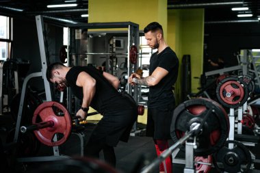 Eğitim koçu, kişisel antrenör eğitimi ve bir müşteriye spor aletleri konusunda yardımcı olmak. dambıl ve halter eğitimi