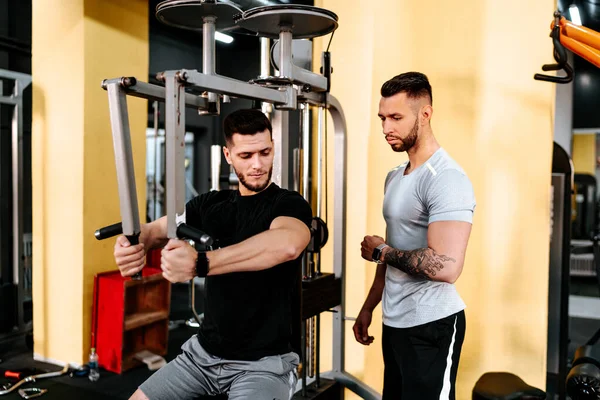 Spor Salonunda Gülen Adam Kişisel Antrenörünün Yardımıyla Göğüs Egzersizleri Yapıyor — Stok fotoğraf