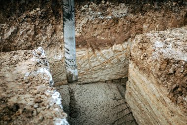Pompa tüpüyle çimento ya da beton döken inşaat işçisi