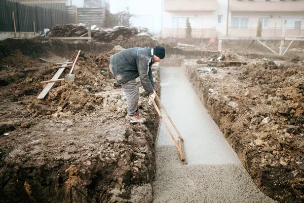 Hombre Nivelación Hormigón Durante Construcción Casa Fundación Casa —  Fotos de Stock