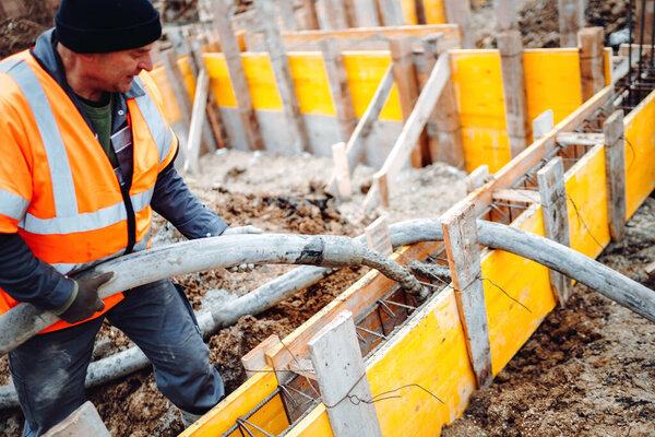 construction site details - building concrete slabs at house construction and pouring cement on reinforcement bars