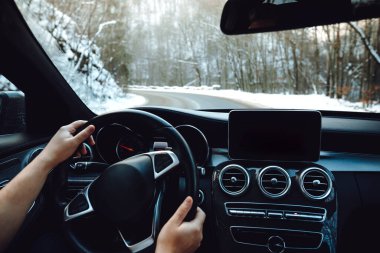 View of the road, drivers view. Man driving on a snowy mountain road