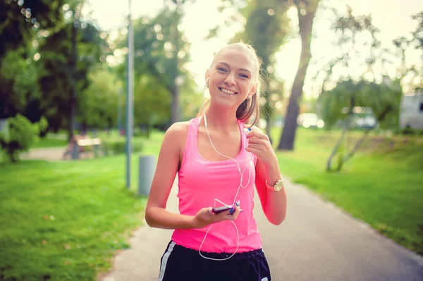 Glad fitness kvinnliga idrottare njuter en löpande träning i parken — Stockfoto