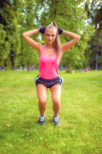 Frumos blonda fata working afară în parc face squats și izolare musculara — Fotografie, imagine de stoc