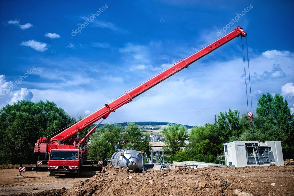 Industrial Crane operating and lifting an electric generator and