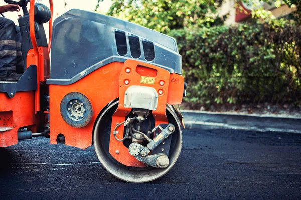 Mannen hard bezig met asfaltering van de aanleg van wegen en de bestrating met zware machines roller compactor — Stockfoto