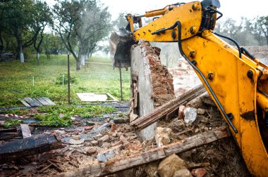 Ekskavatör yükleme yıkım enkaz ve inşaat alanında geri dönüşüm için beton atık bir beton wall.bulldozer yıkılması.