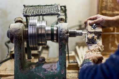 Mobilya ve ahşap nesneleri oluşturmak için woodturning aracı ve diğer sanayi araçları kullanarak çalışan eller