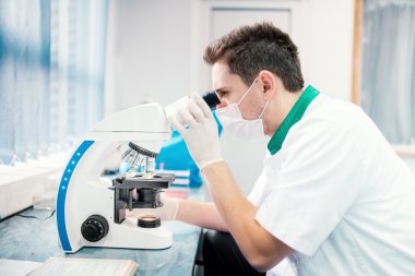 Erkek bilim adamı, kimyager laboratuar mikroskobu ile çalışma