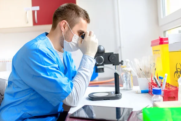 Químico masculino que trabaja con microscopio en laboratorio — Foto de Stock