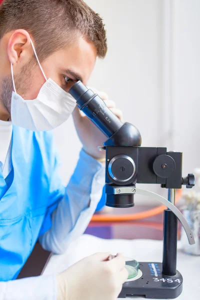 Retrato de químico que trabalha com microscópio em laboratório especial — Fotografia de Stock