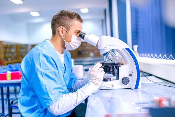 Hombre científico, químico que trabaja con microscopio en laboratorio farmacéutico — Foto de Stock