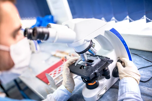 Investigador químico trabajando con microscopio para evidencia forense — Foto de Stock