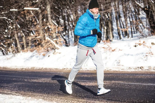 Unga idrottare går för en körning utomhus i snö, hardcore utbildning och jogging — Stockfoto