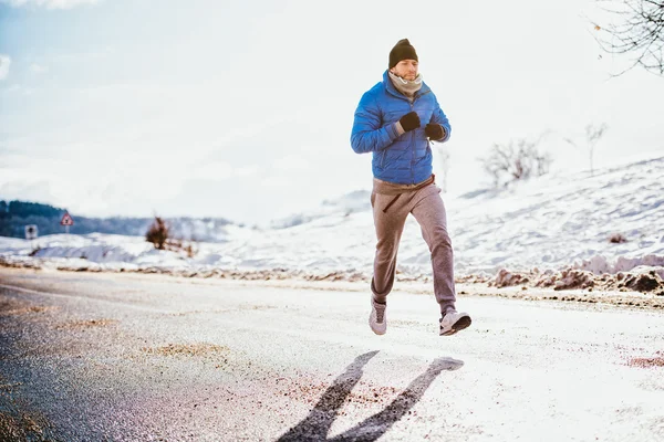 Close-up of man running and jogging on a cold winter day — Stock Photo, Image