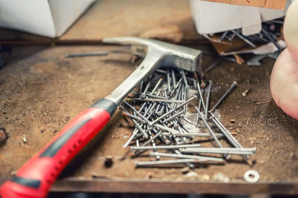 Μεγέθυνση του επαγγελματικά εργαλεία σφυρί, καρφιά και κατασκευή στον πάγκο εργασίας — Φωτογραφία Αρχείου