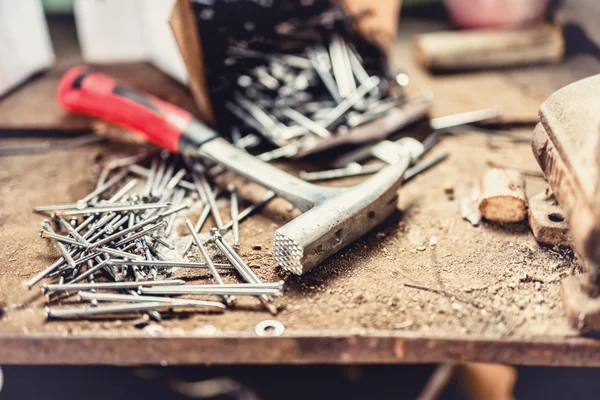 Marteau professionnel ancien et d'occasion avec de nouveaux clous sur chantier, établi ou atelier — Photo