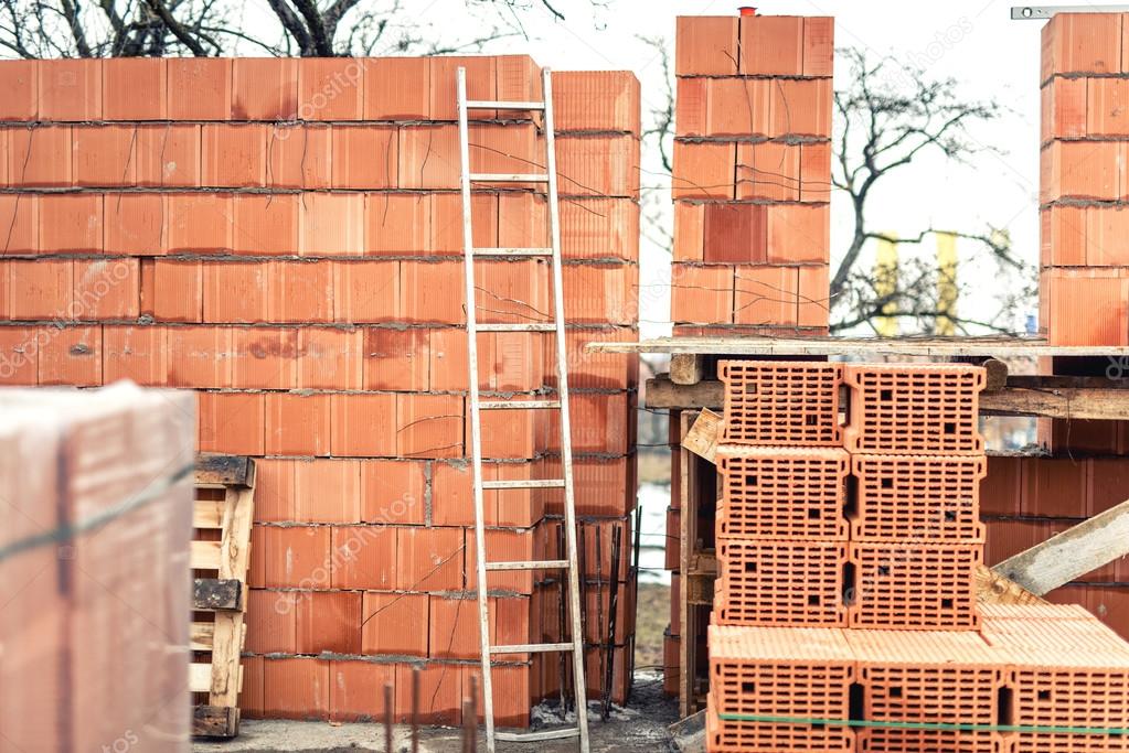 Wall building with professional bricks, construction site of new house