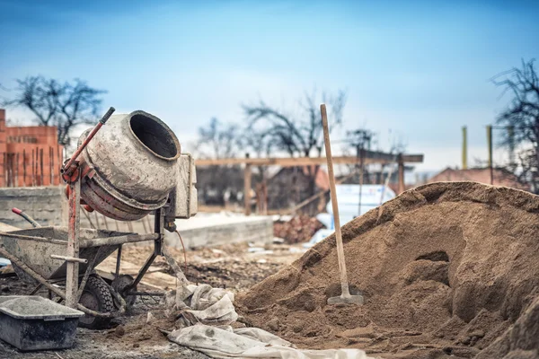 Máquina misturadora de cimento no canteiro de obras, ferramentas e areia — Fotografia de Stock