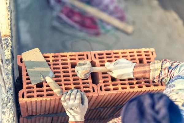 Construction worker building walls and fixing bricks with mortar and rubber hammer — Stock Photo, Image