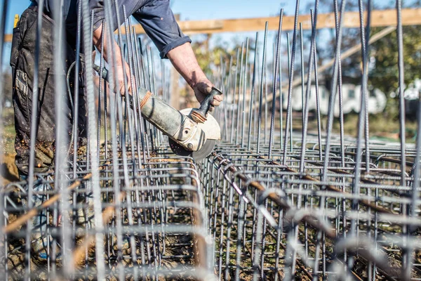 Egy sarokcsiszoló segítségével vágott acél rudak részére megerősítés építkezésen dolgozó — Stock Fotó