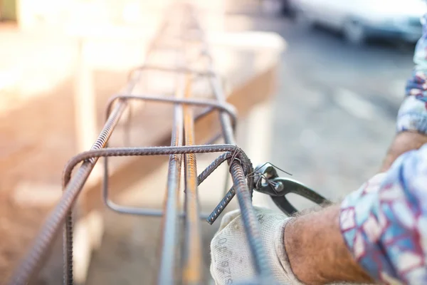 Detalles de la infraestructura - Trabajador de la construcción manos de fijación de barras de acero con varilla de alambre para el refuerzo de hormigón — Foto de Stock