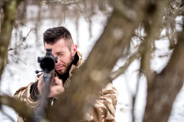 Військовослужбовець зі снайпером на полі бою, використовуючи дерева як камуфляж — стокове фото