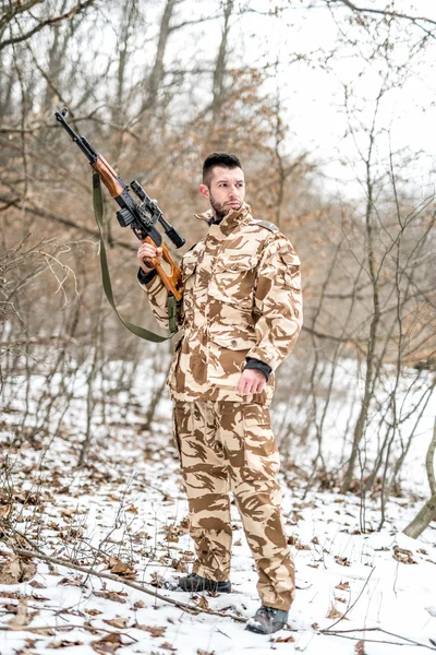 Armén trooper och soldat hålla ett vapen och tittar bort — Stockfoto