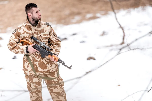 Military trooper, ranger, holding a machine gun on the battlefield — Stock Photo, Image
