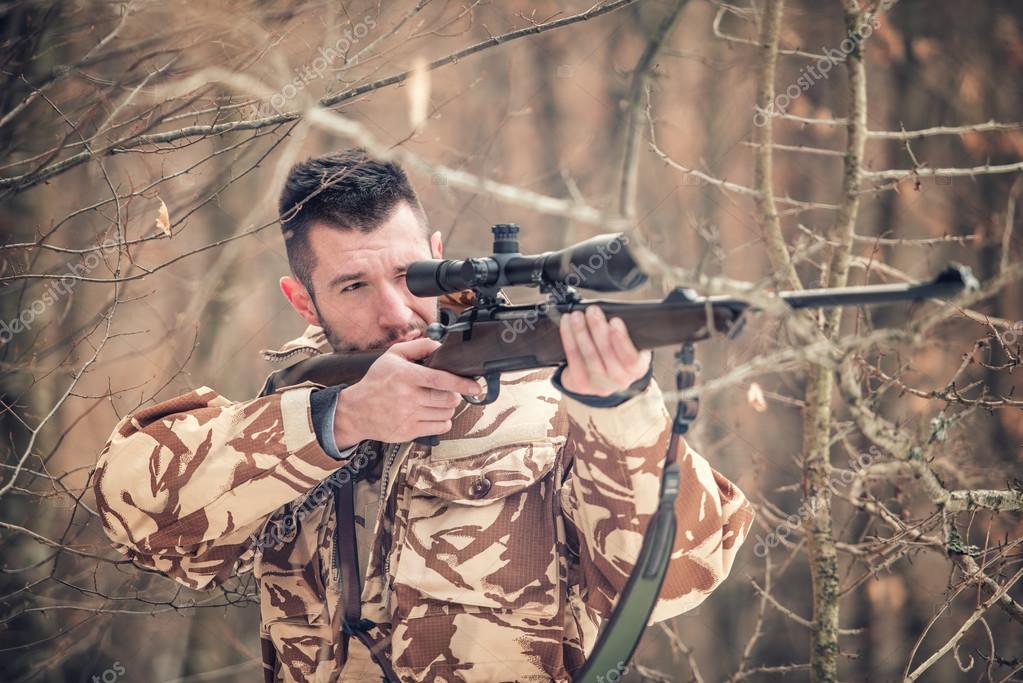 Man holding a sniper and shooting on an open season, looking through