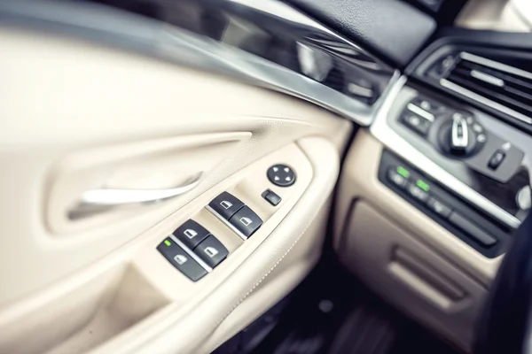 Detalles interiores de cuero de coche de la manija de la puerta con controles de ventanas y ajustes. Controles de ventana de coche de coche moderno —  Fotos de Stock