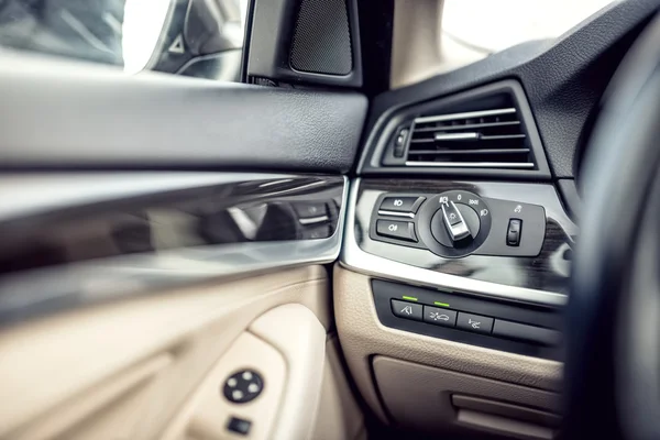 Interior de coche moderno con cuero y detalles premium. Control de ajuste de faros y detalles de la cabina —  Fotos de Stock