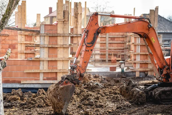 Carregador de escavadeira tipo pista trabalhando na terra e carregando no local de construção da casa — Fotografia de Stock