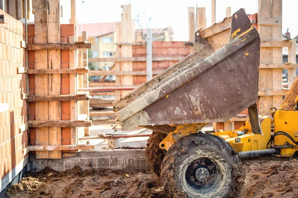 Dumper lastbil lossning grus, sand och stenar på byggarbetsplatsen. Bricklayering och arbetar på byggarbetsplatsen — Stockfoto