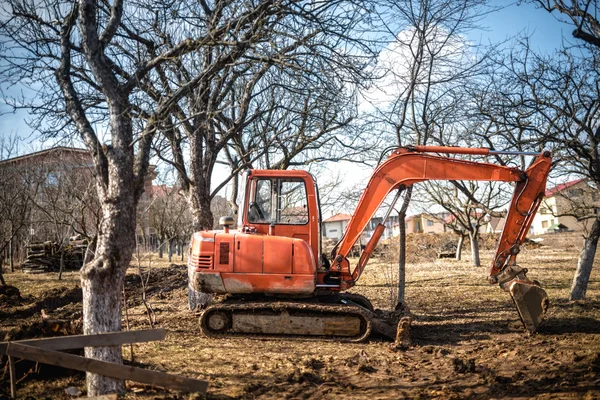 Chargeuse-pelleteuse sur chenilles et pelleteuse travaillant sur la terre et le chargement sur le chantier de construction de la maison — Photo