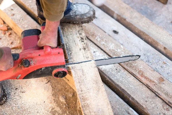 Werknemer houten snijplanken op contruction site met elektrische cirkelzaag — Stockfoto