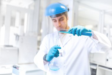 Bilim adamı doktor tüp bebek örnekleri alarak ve sonuçları karşılaştırmak için laboratuvar şişesi kullanarak