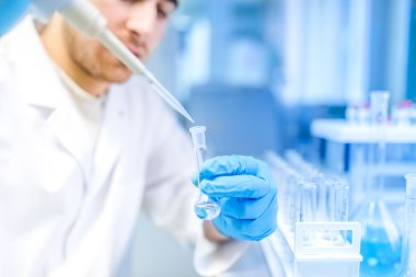 Özel laboratuvar veya sağlık odası örnekleri sıvı çıkarılması için tıbbi aracını kullanarak erkek bilim adamı